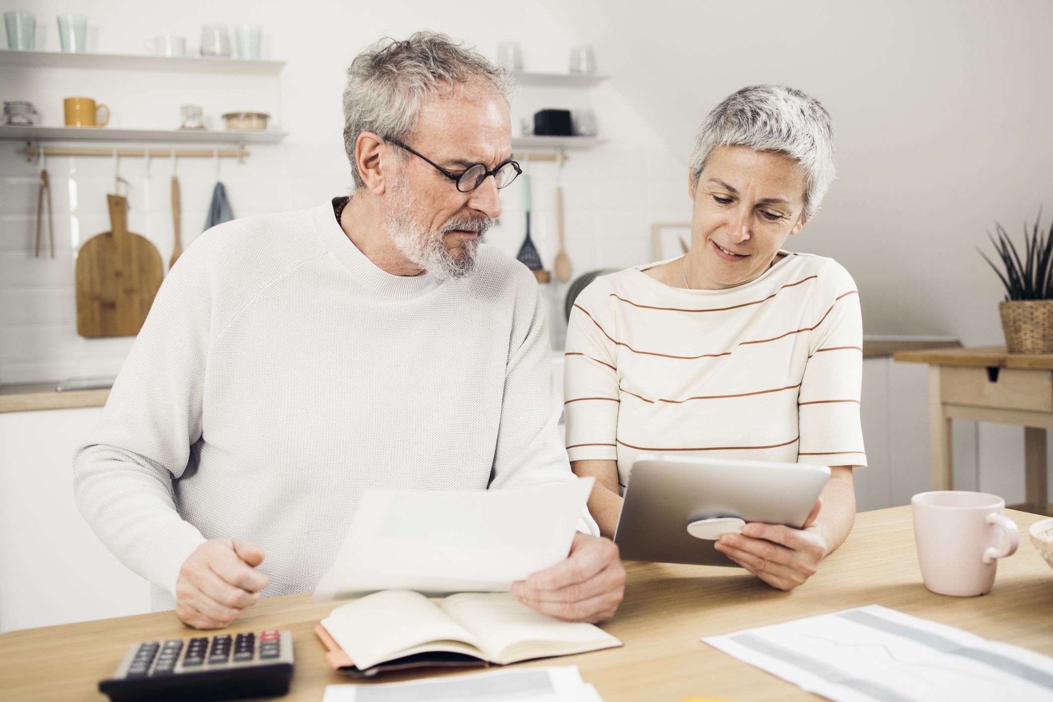 Older adults reviewing benefit deposits and a household budget at home